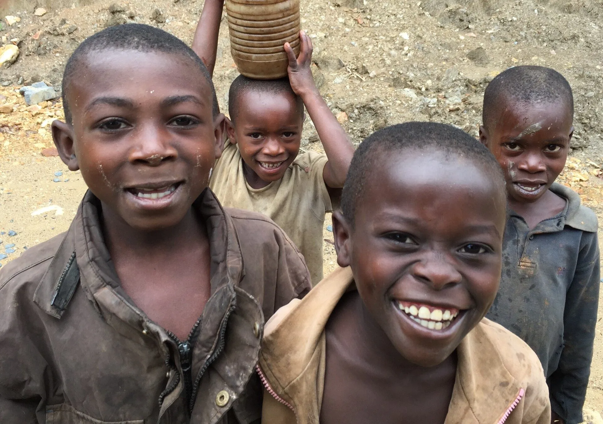 Smiling village children with a water jug